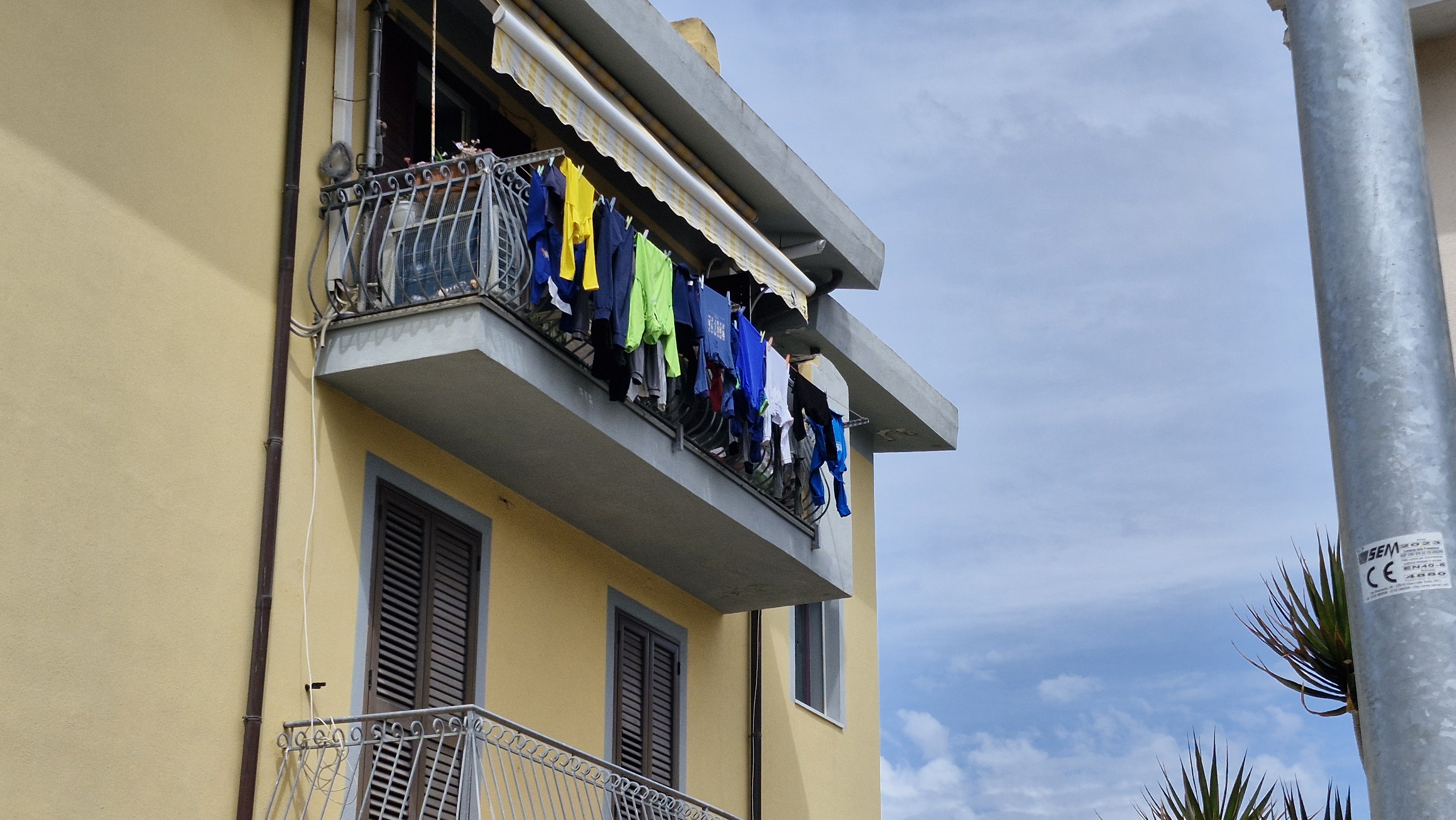 Cycling gear drying on a balcony in a Sardinian town.