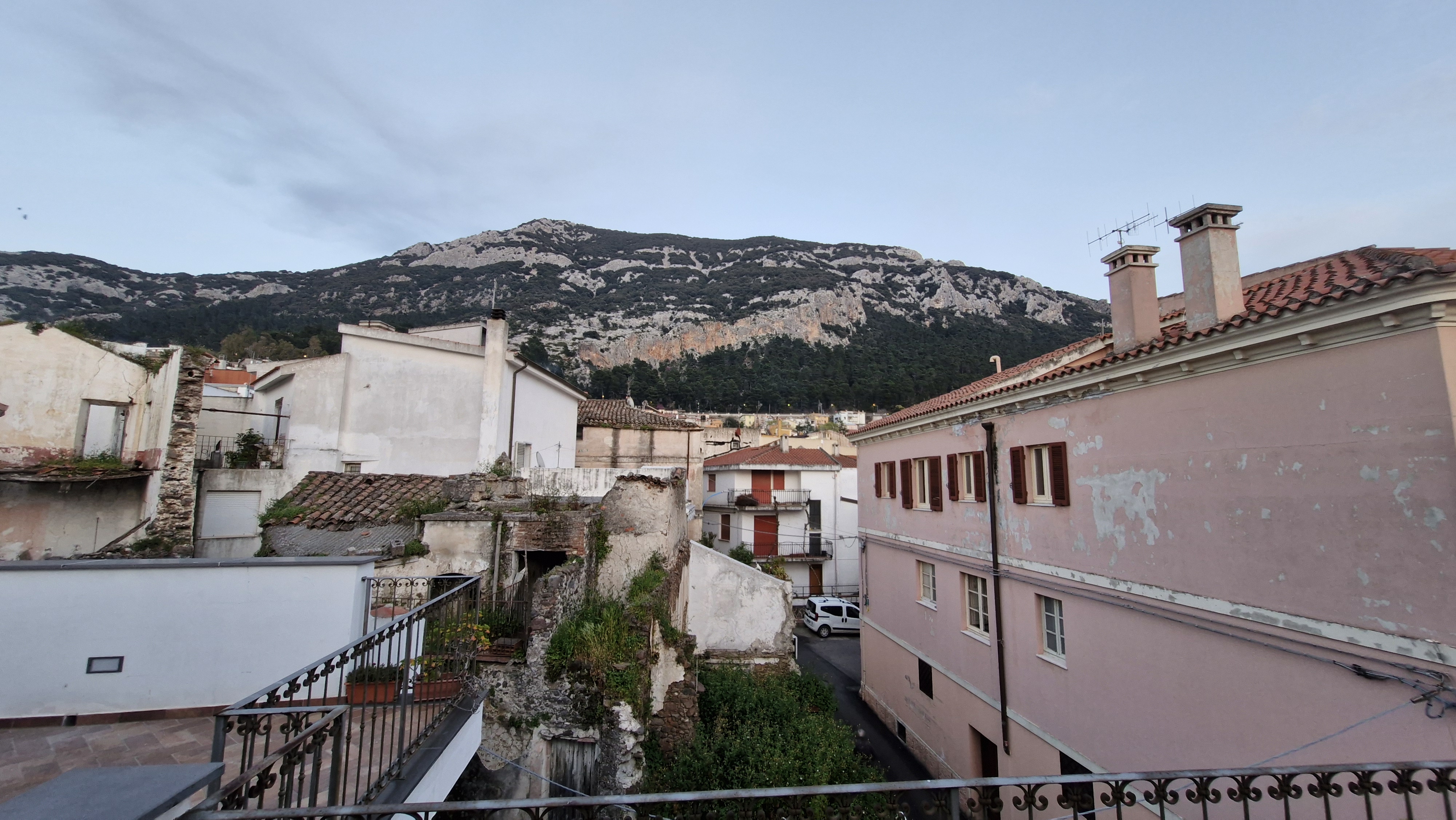View over the rooftops of Dorgali with mountains in the background.